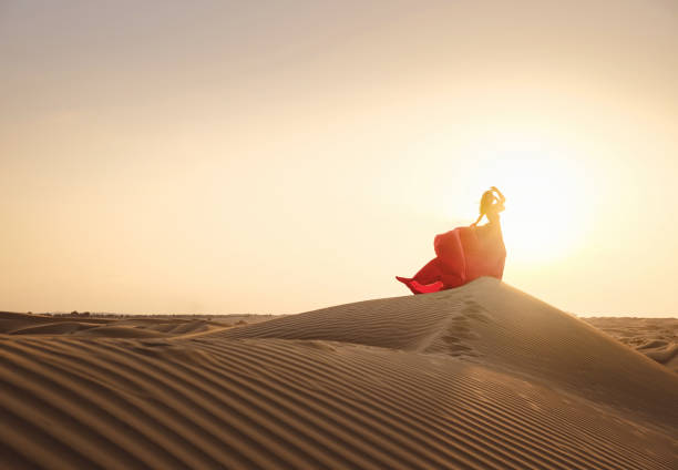 Golden hour flying dress photoshoot in Dubai desert dunes.
