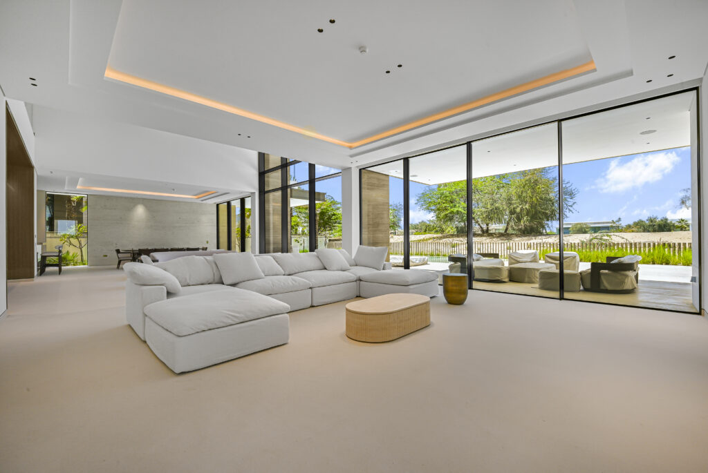 Best villa photographer in Dubai capturing spacious luxury living room with floor-to-ceiling windows and pool view for high-end property listing