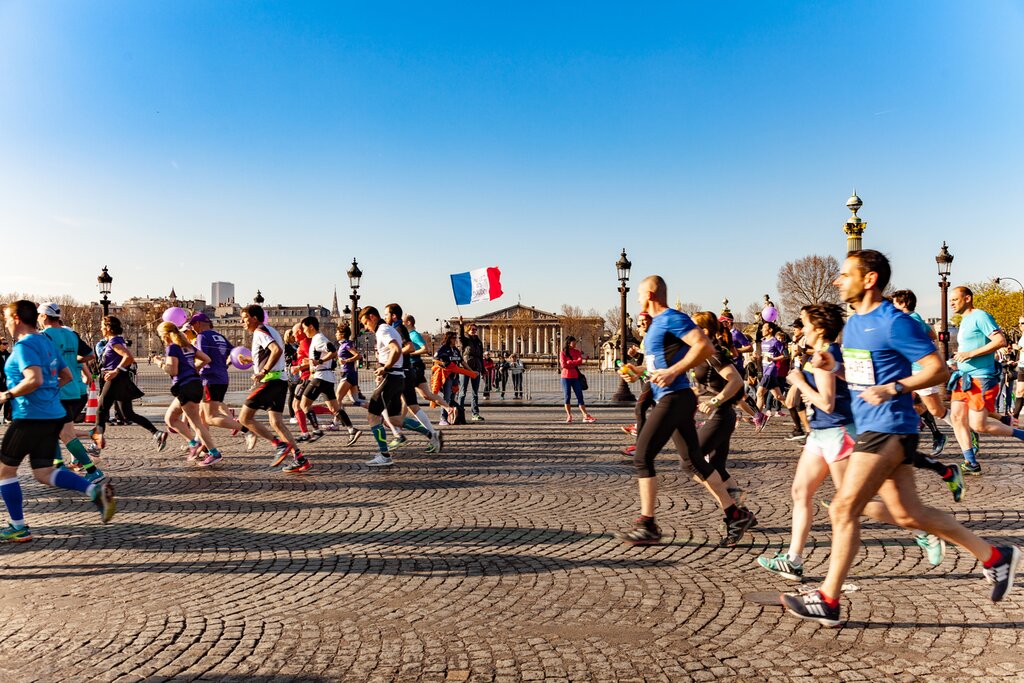 Runners competing in a marathon event in Dubai at sunrise, with Burj Khalifa and city skyline in background, captured by Zypix event photography.